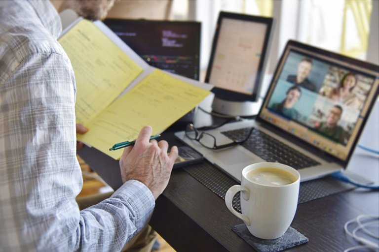 man-working-from-home-signing-contract-documents-while-in-a-virtual-video-chat-meeting-on-computer_t20_O0RK6b.jpg